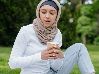 Person holding a cup of tea looking peaceful outdoors