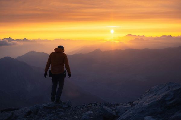 Sunset view over mountains with silhouette of a person